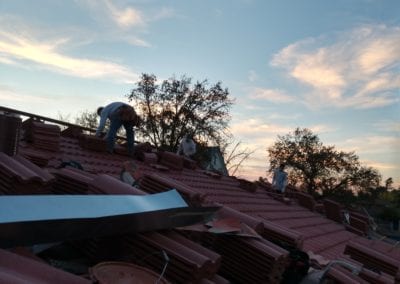 Construction workers adding new roofing tiles.